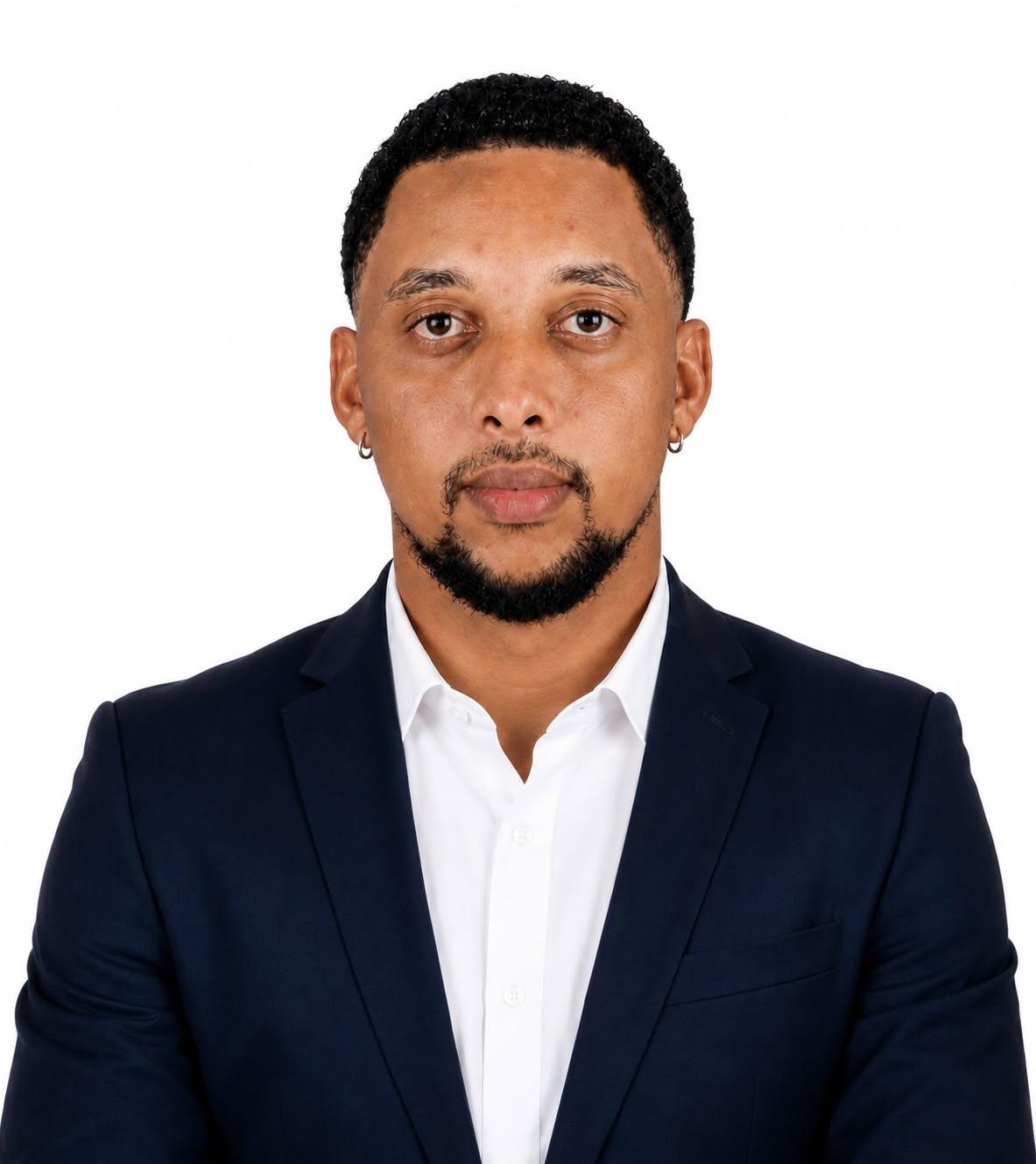 Portrait of Tiago Pires in a navy blazer and white shirt.